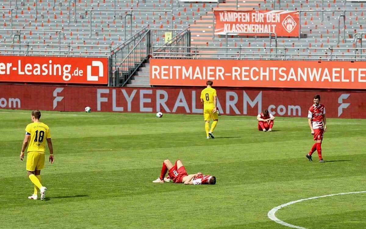 Spieler der rothosen nach abstieg liegend auf spielfeld Spieler der rothosen nach abstieg liegend auf spielfeld